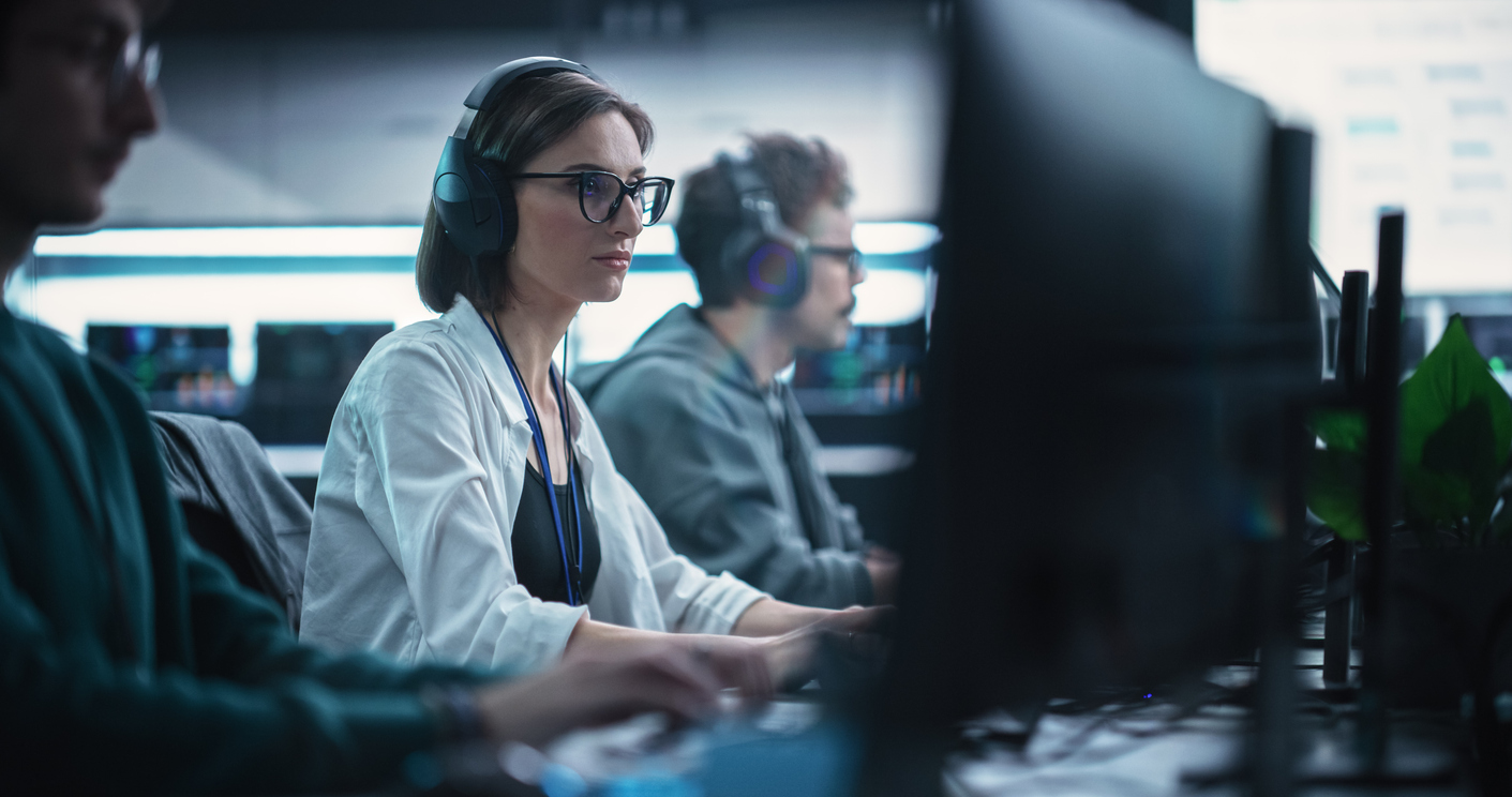 Focused Young Female Software Developer Working on Computer Together with Two Creative Male Colleagues. Data Protection Center with Servers, Storage Hardware and eBusiness Research